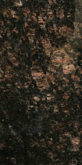 A close up of a black and brown granite counter top.