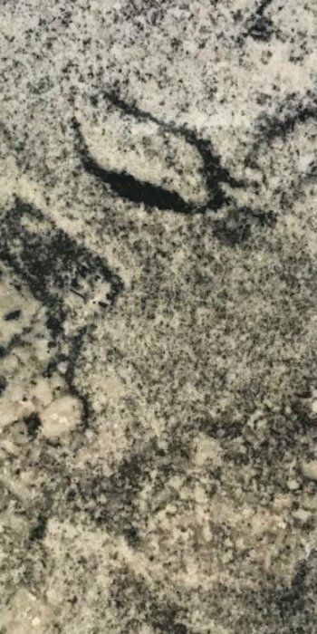 A close up of a granite counter top with a black and white pattern.