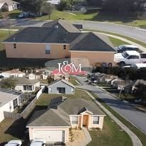 Aerial view of a tan residential neighborhood with light-colored single-family homes and roads.