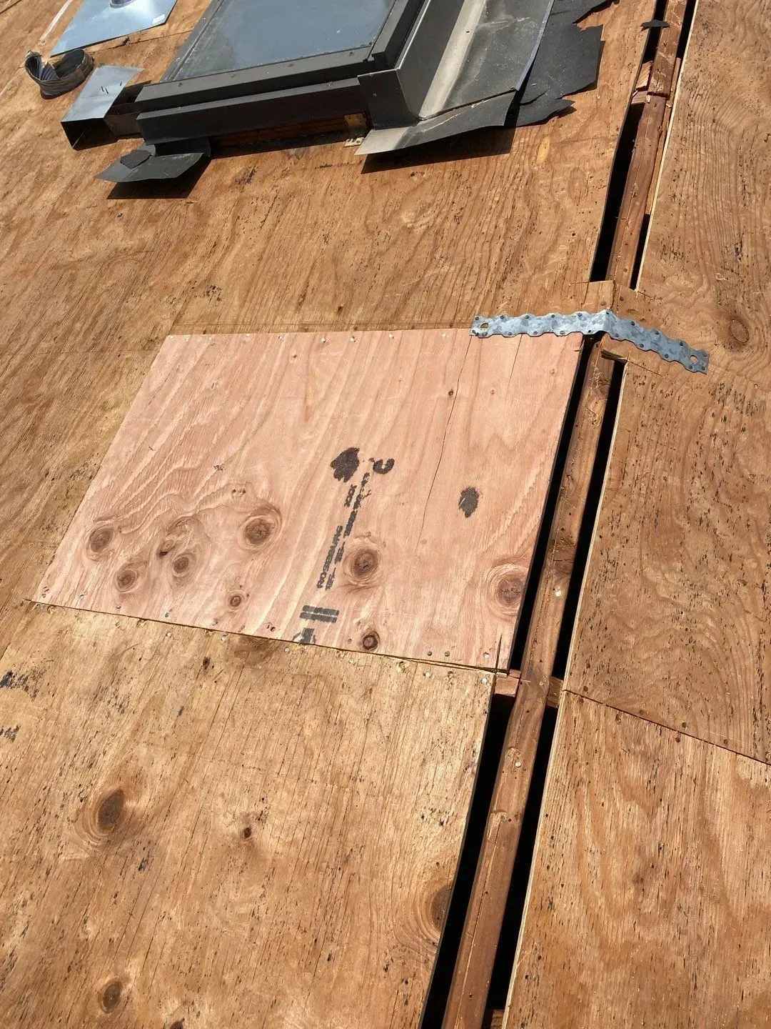 Plywood covering on a roof, with hinge. Skylight and wood slats visible.
