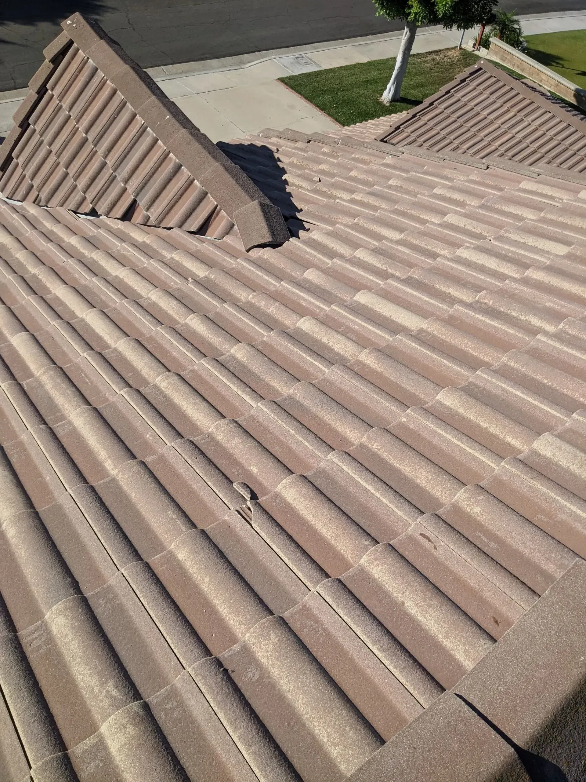 Clay tile roof on a house; tan and brown tiles with a pitched design.