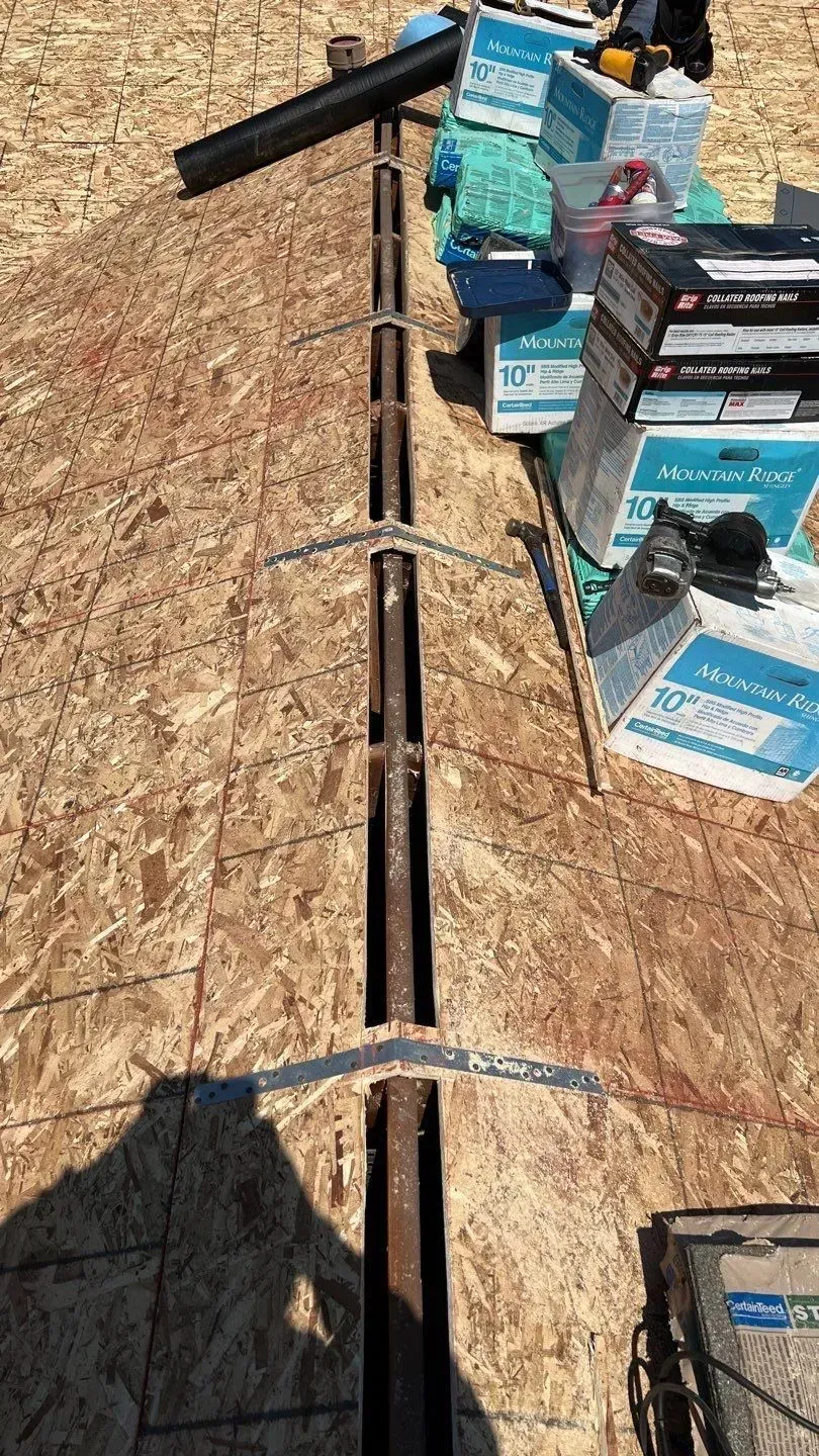 Overhead view of a roof valley with metal flashing and roofing materials.