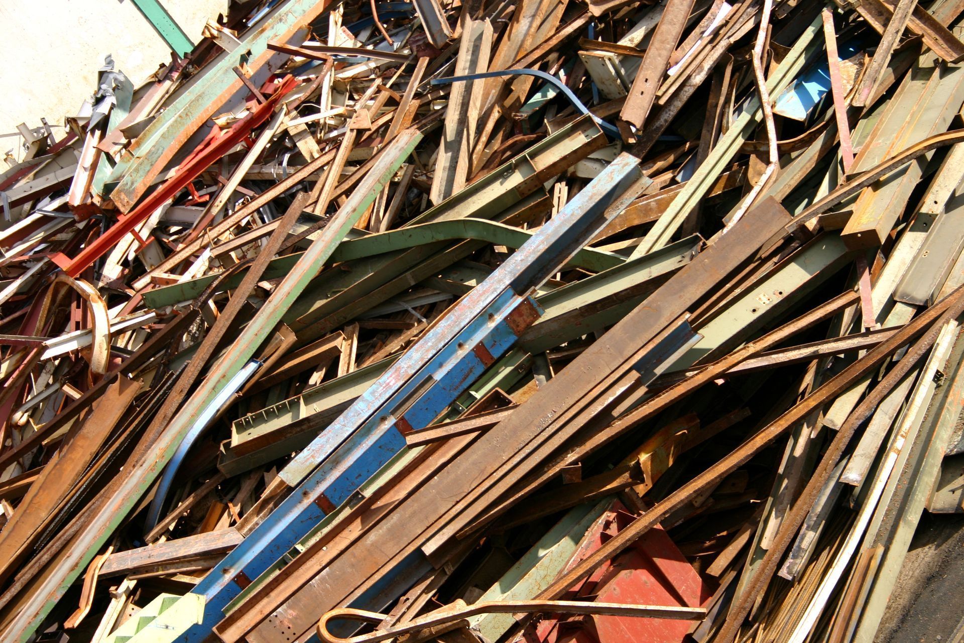 Pile of mixed scrap wood and metal debris in a junkyard, with weathered boards and beams.