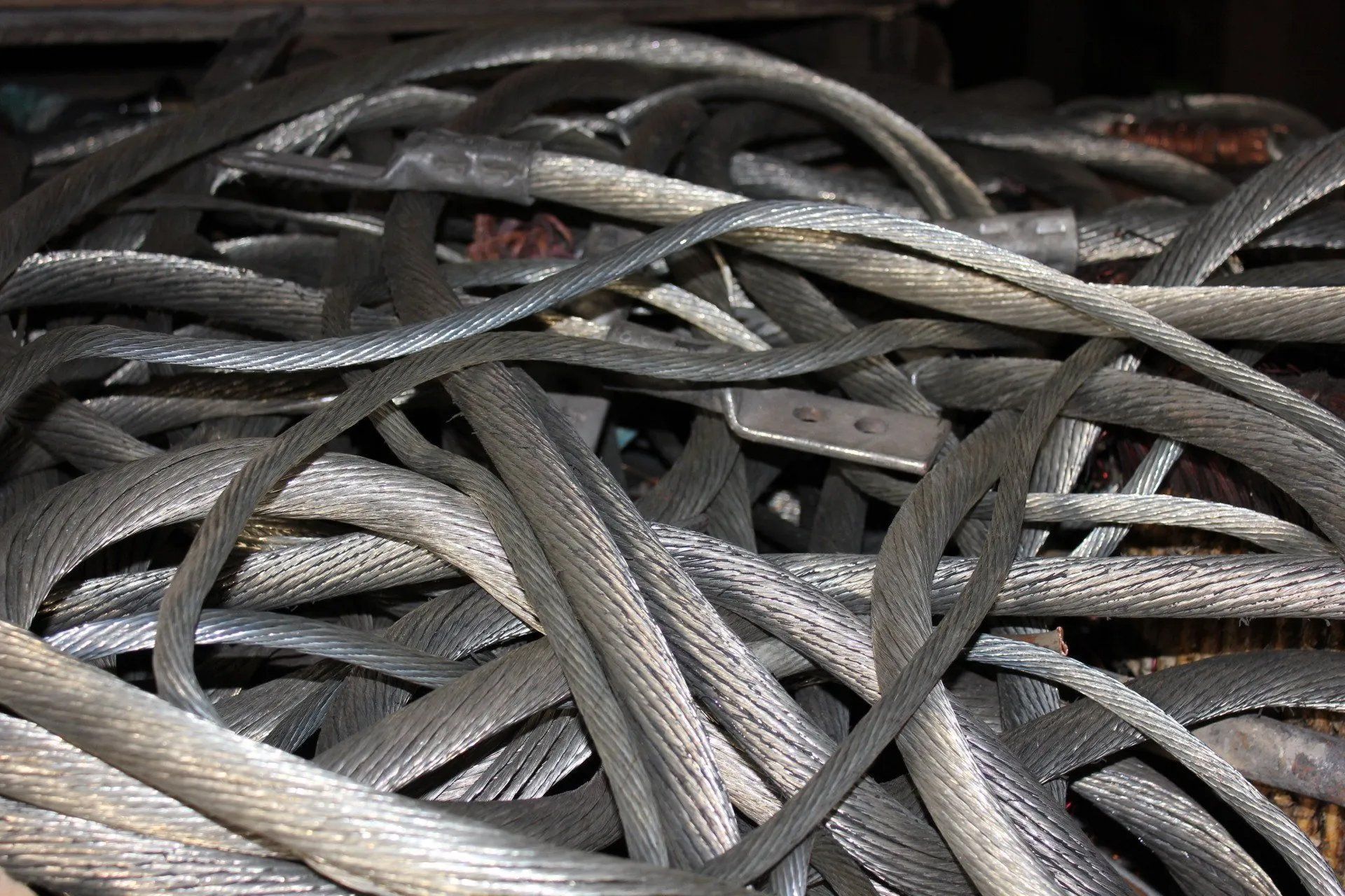 Piled tangled steel cables and wires in a close-up industrial scene