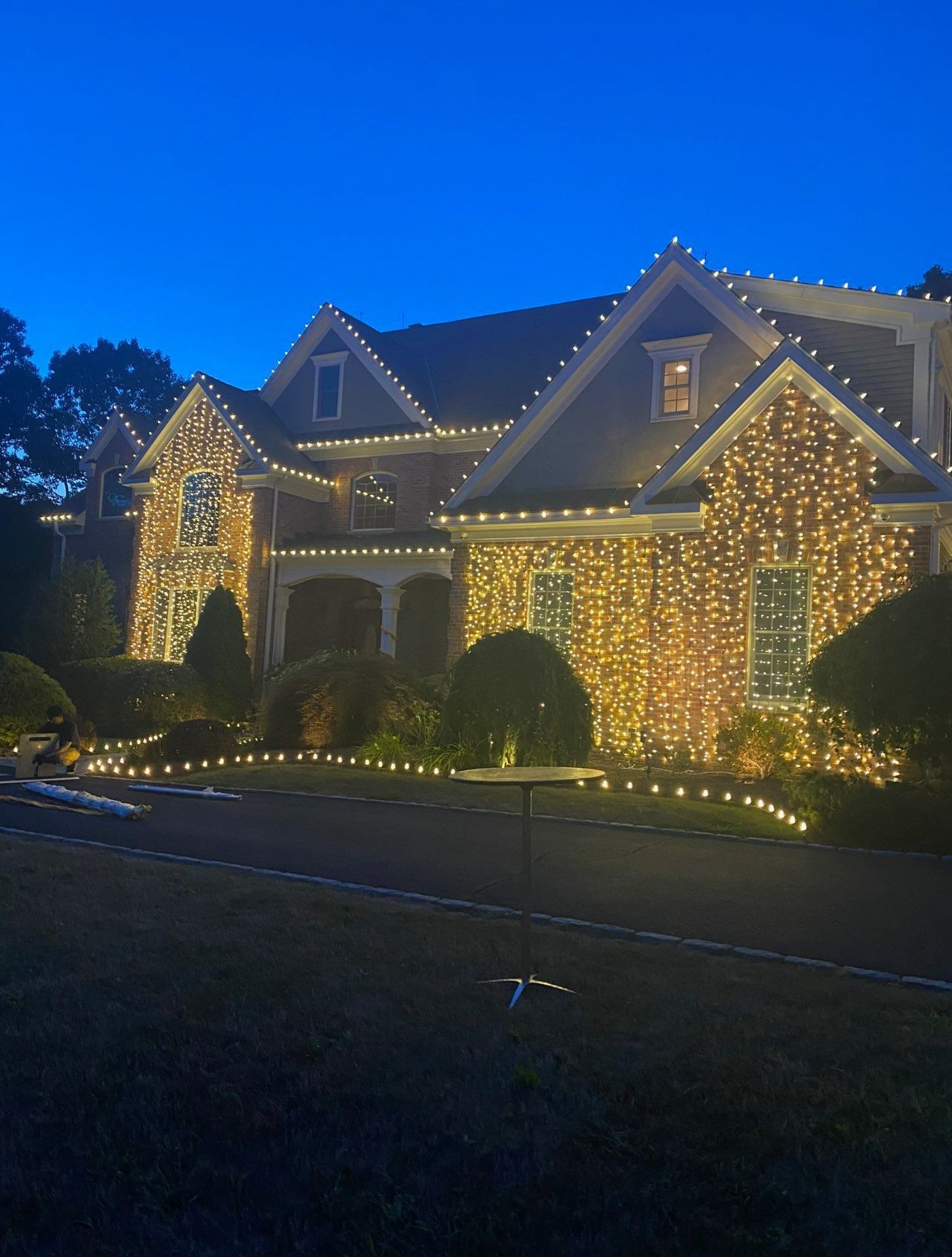 A large house is decorated with Christmas lights at night