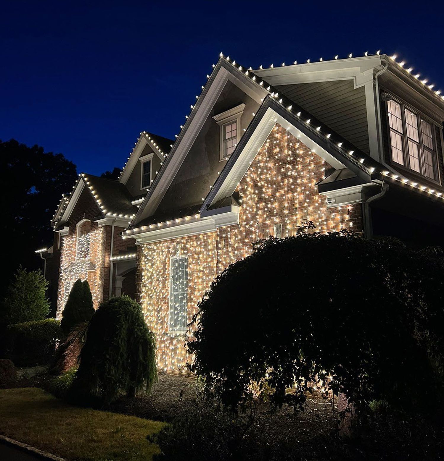 A house is lit up with Christmas lights at night