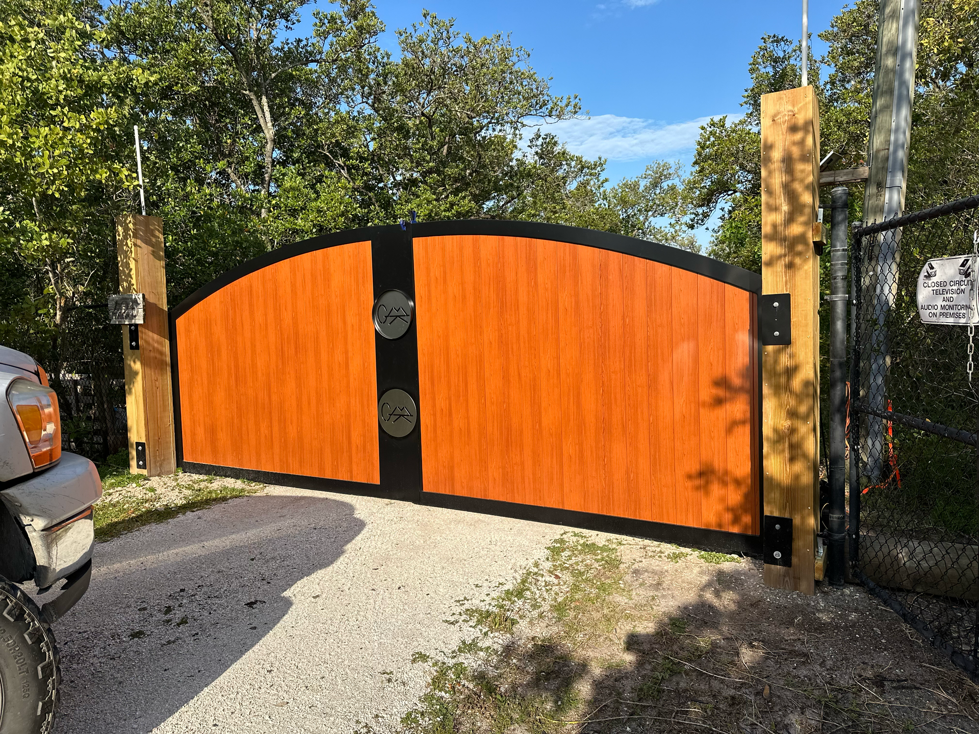 A car is parked in front of a wooden gate.