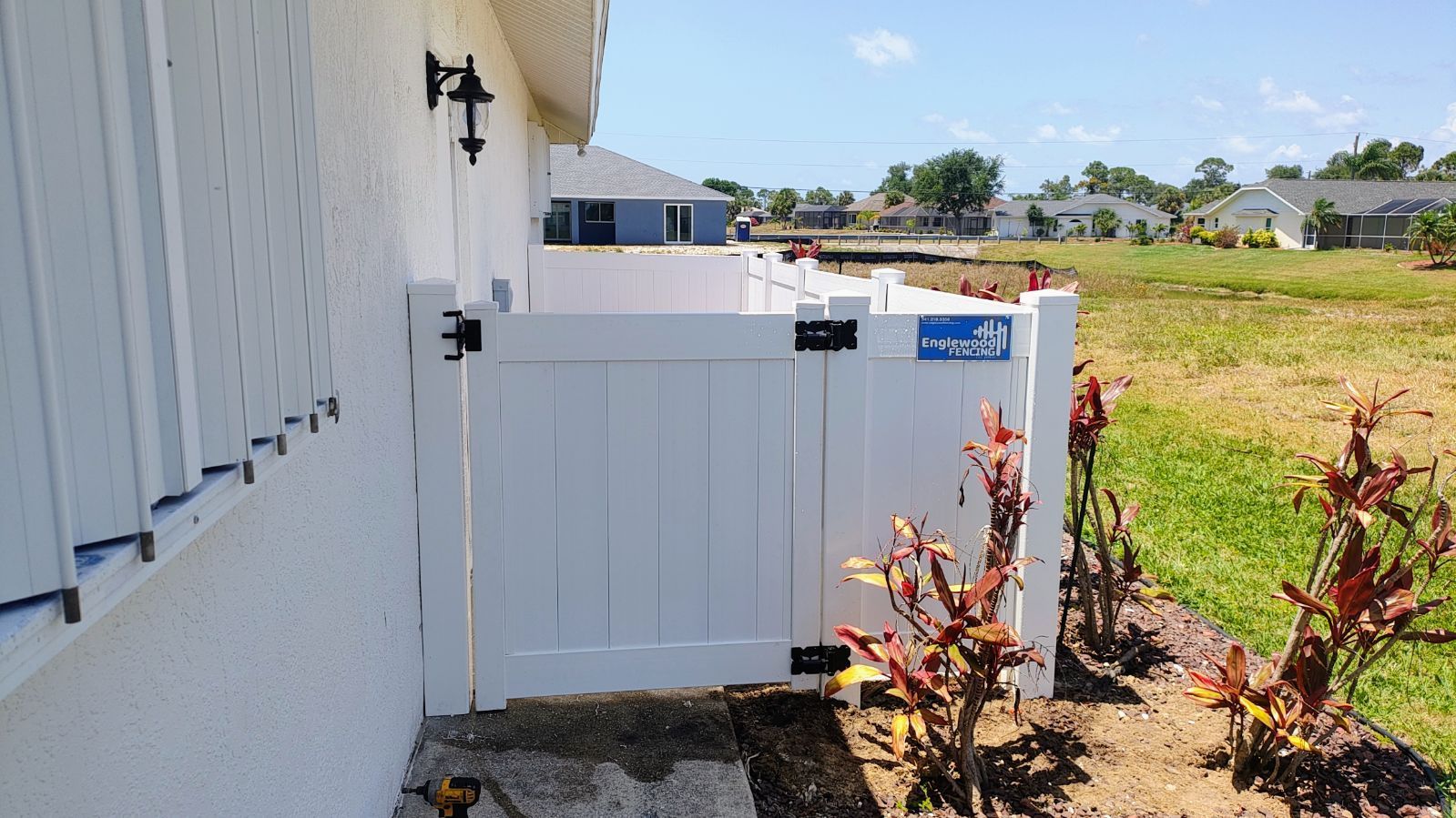 A white fence is sitting on the side of a house.