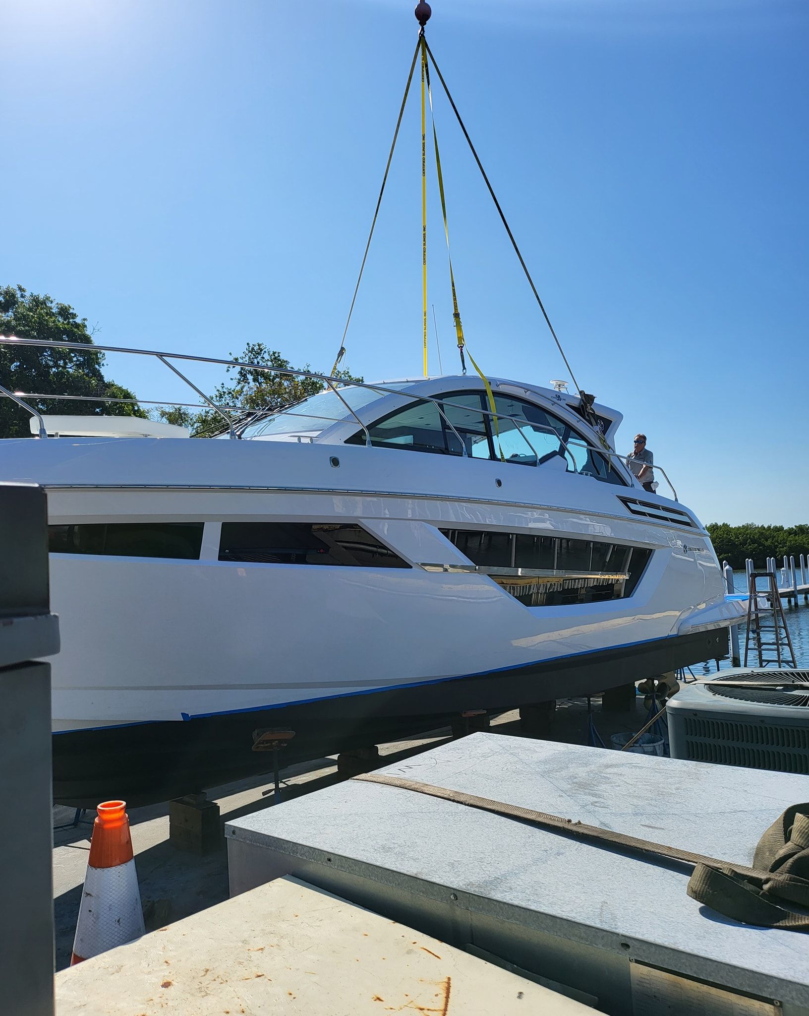 A boat is being lifted into the water by a crane