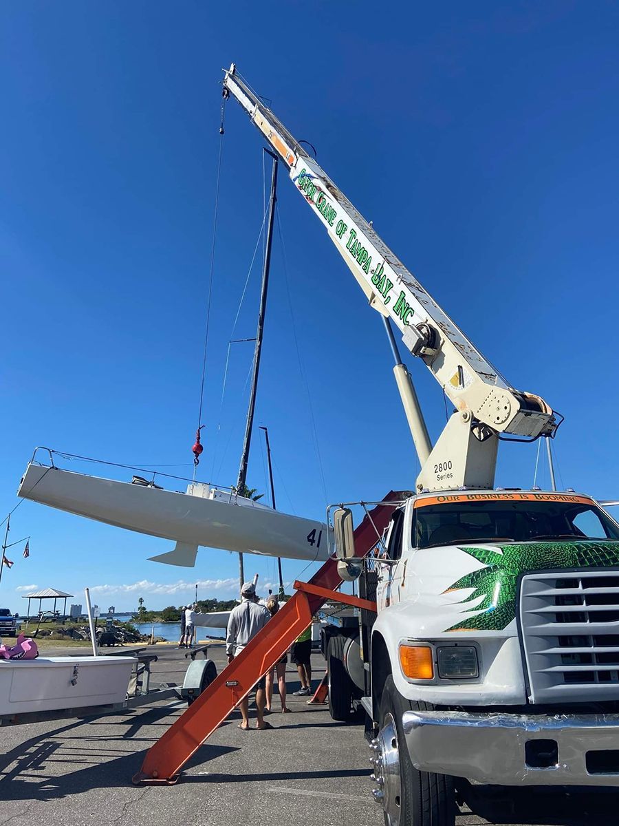 A white truck with a crane on top of it