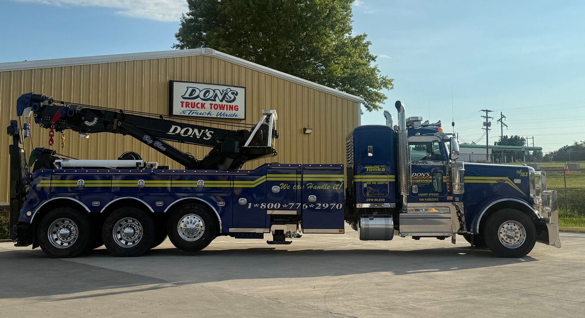 A blue wrecker tow truck with yellow accents
