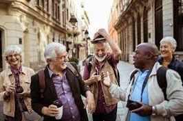 Group of people laughing, walking down a European street. Some are wearing backpacks and holding cameras.