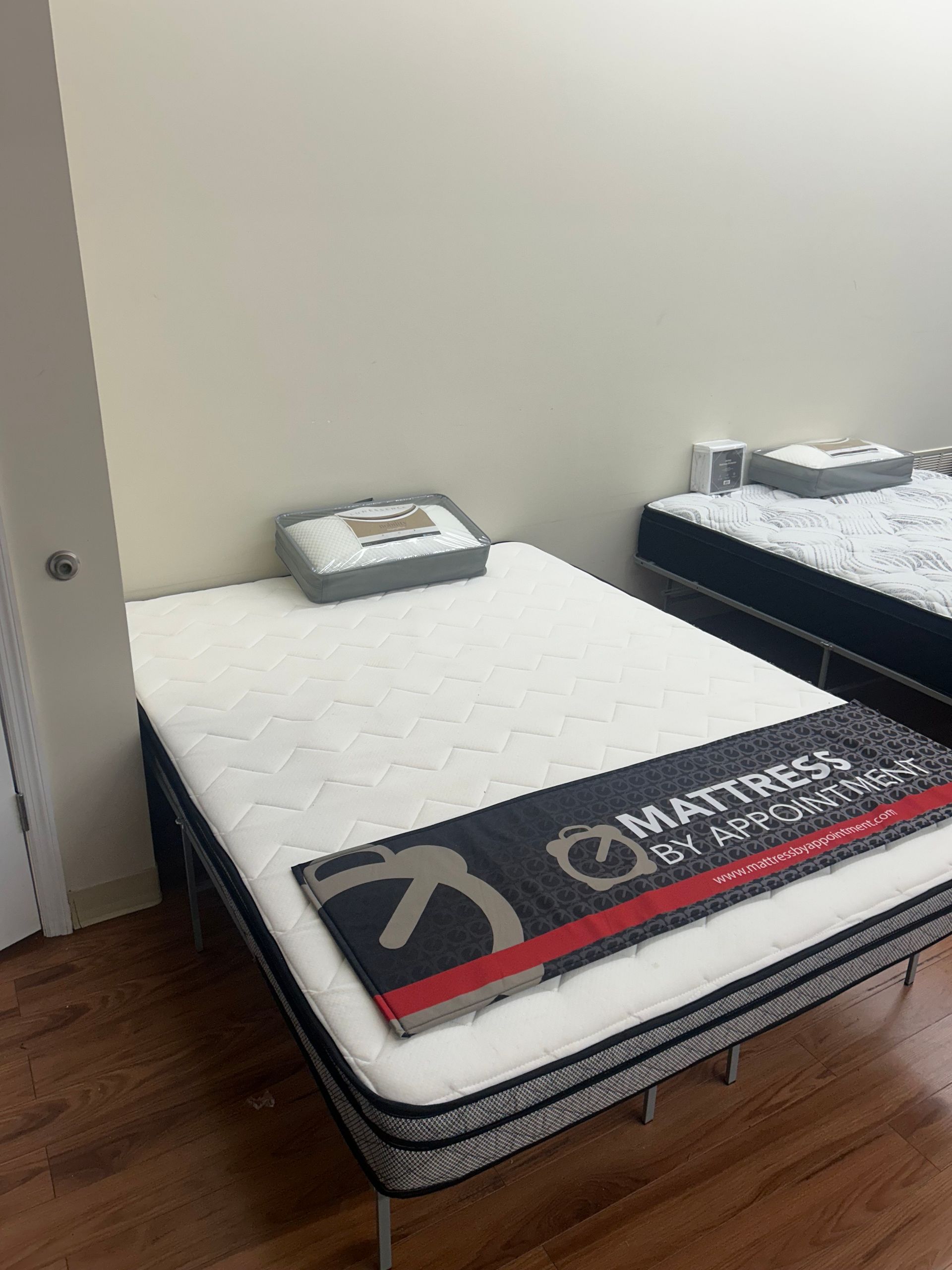 Mattresses on display in a showroom, white and dark blue colors visible