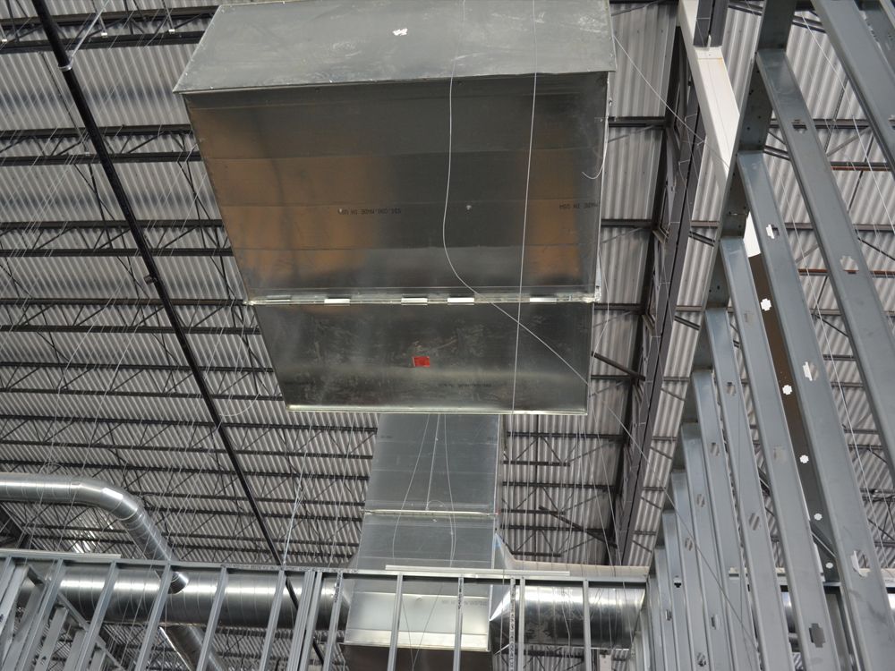 A large metal box is hanging from the ceiling of a building.
