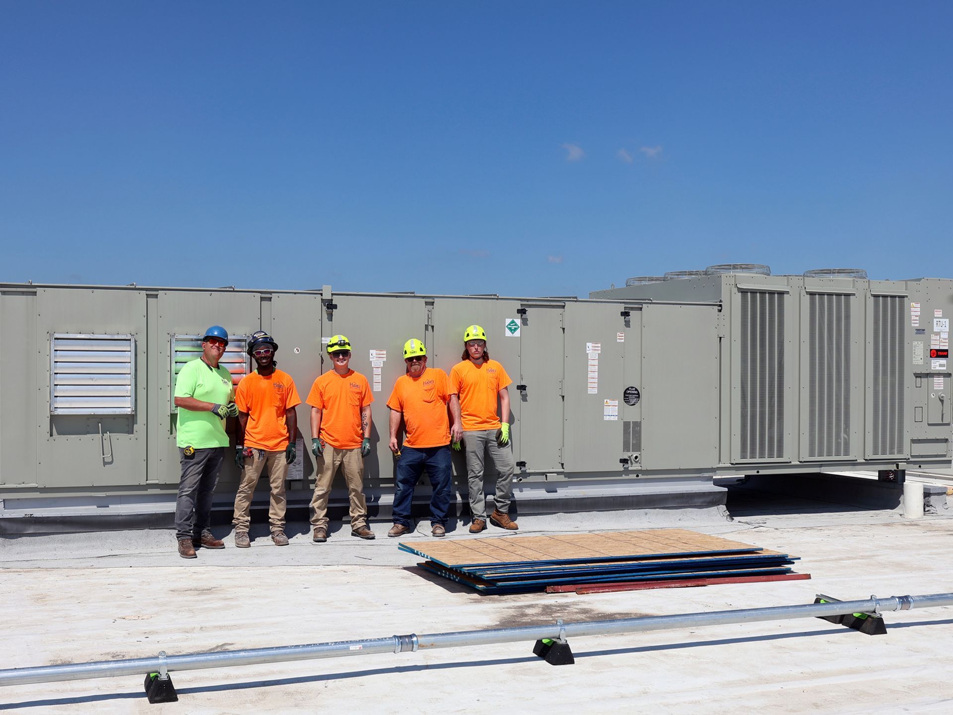 A group of construction workers are standing on top of a roof.