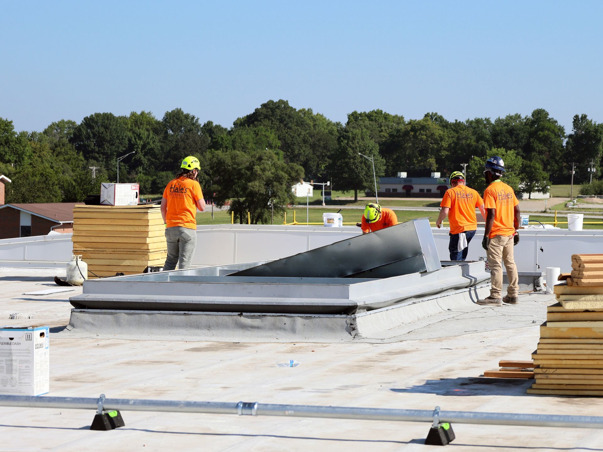 A group of construction workers are working on a roof.