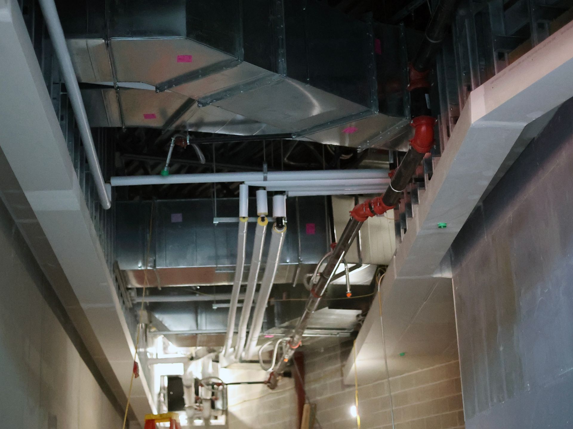 A ceiling with a lot of pipes hanging from it