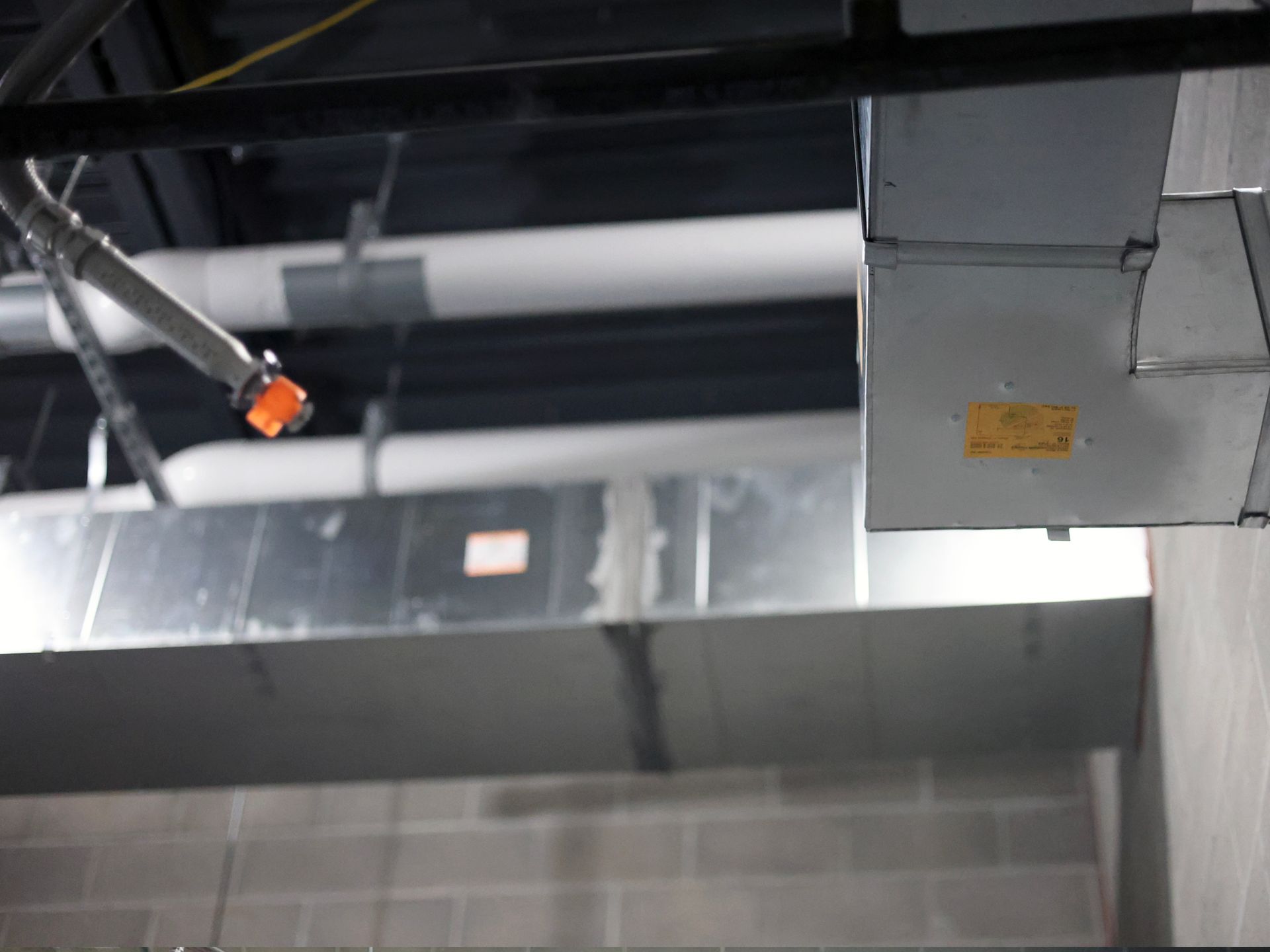 A ceiling with a lot of pipes hanging from it