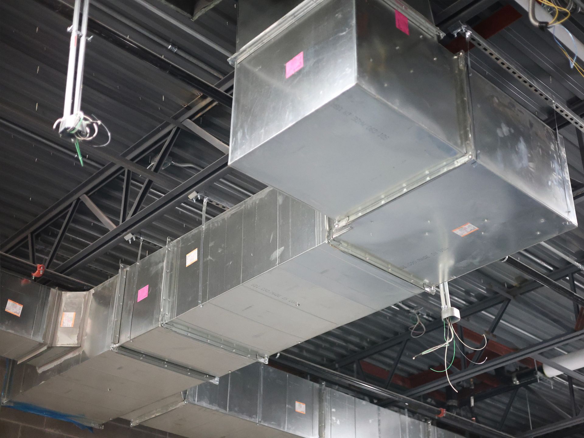 A bunch of metal pipes hanging from the ceiling of a building
