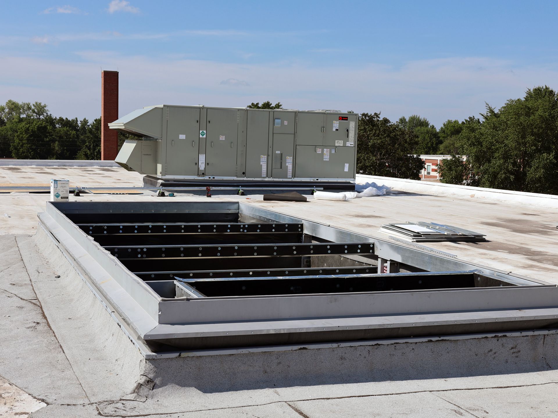 The roof of a building with a chimney in the background