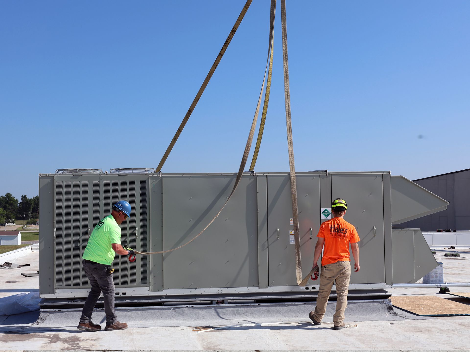 Two men are working on the roof of a building