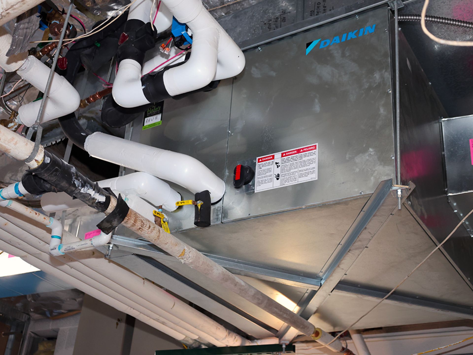A bunch of pipes are hanging from the ceiling of a building.