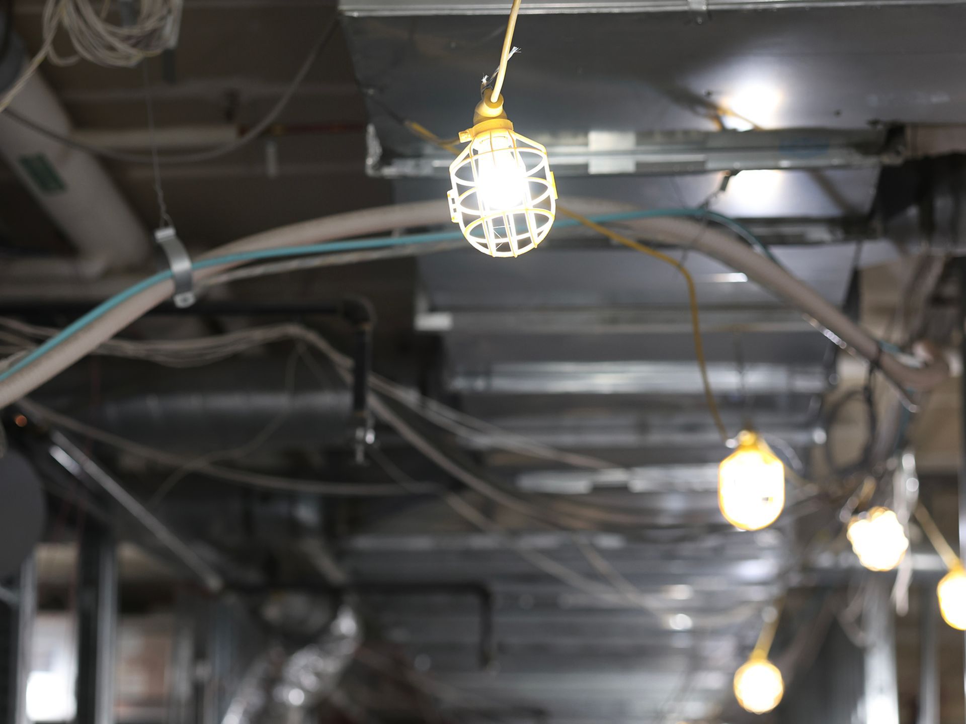 A light bulb is hanging from the ceiling of a building