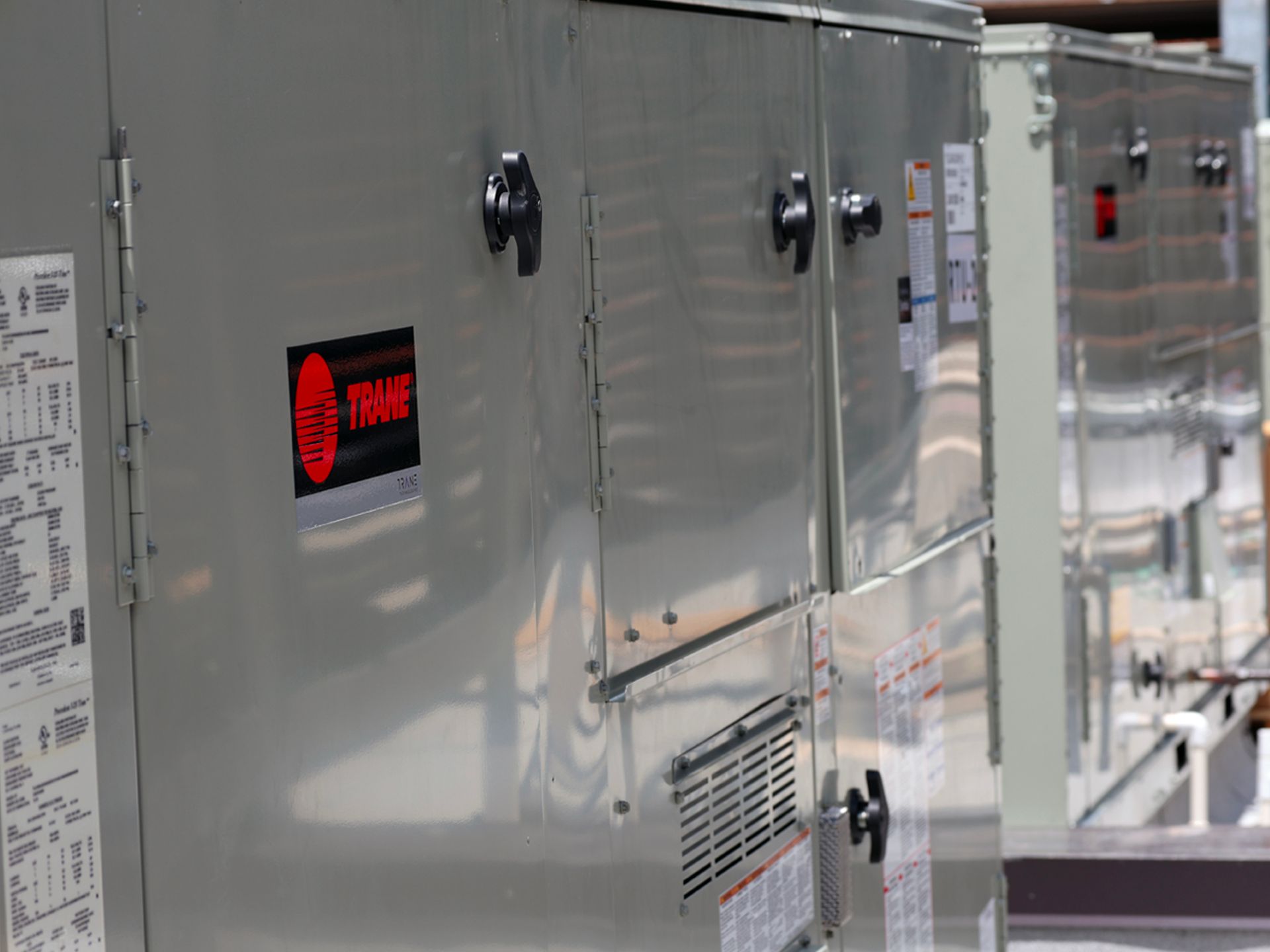 A close up of a stainless steel box with a red sticker on it.