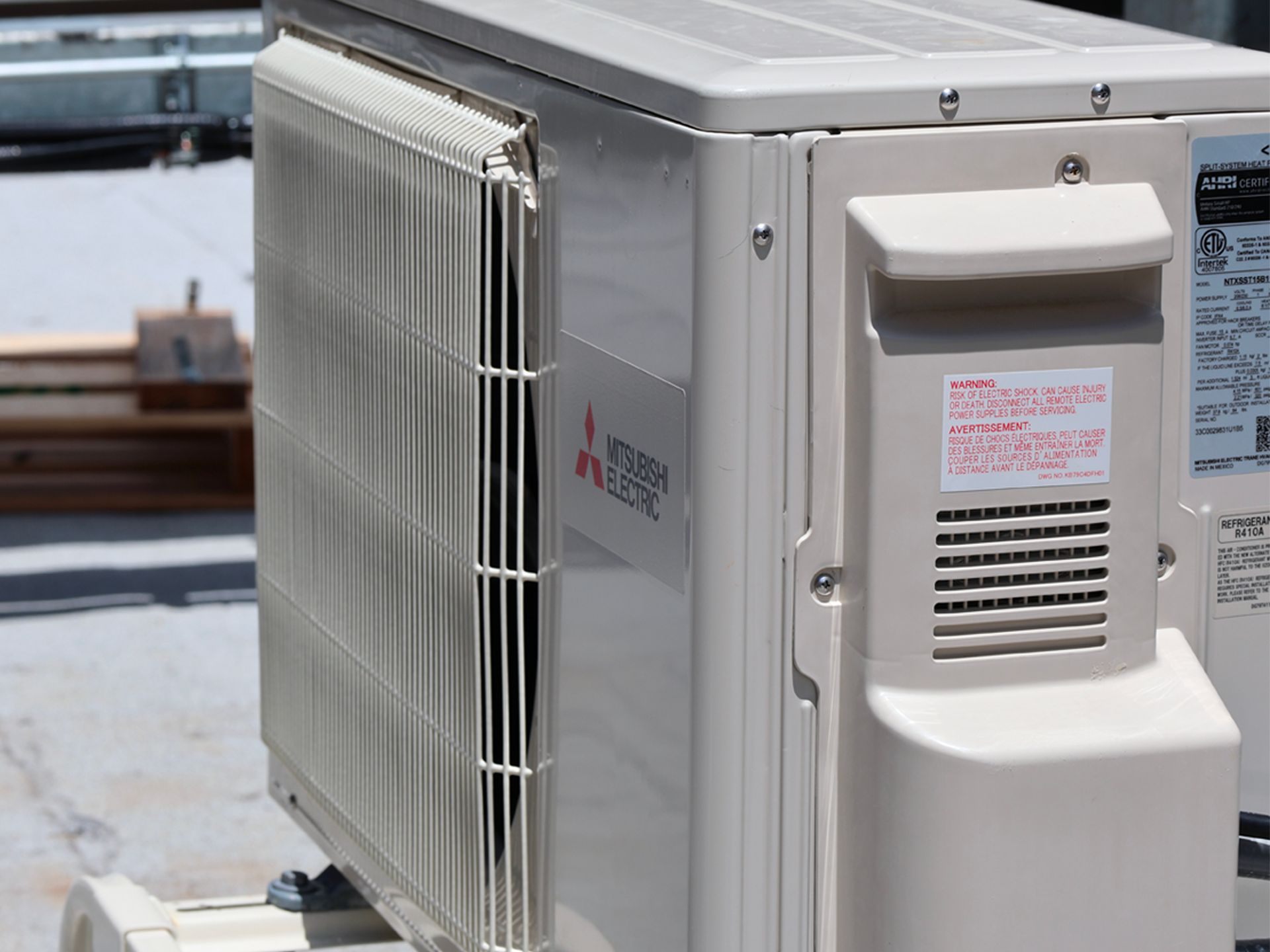 A mitsubishi air conditioner is sitting on top of a roof.
