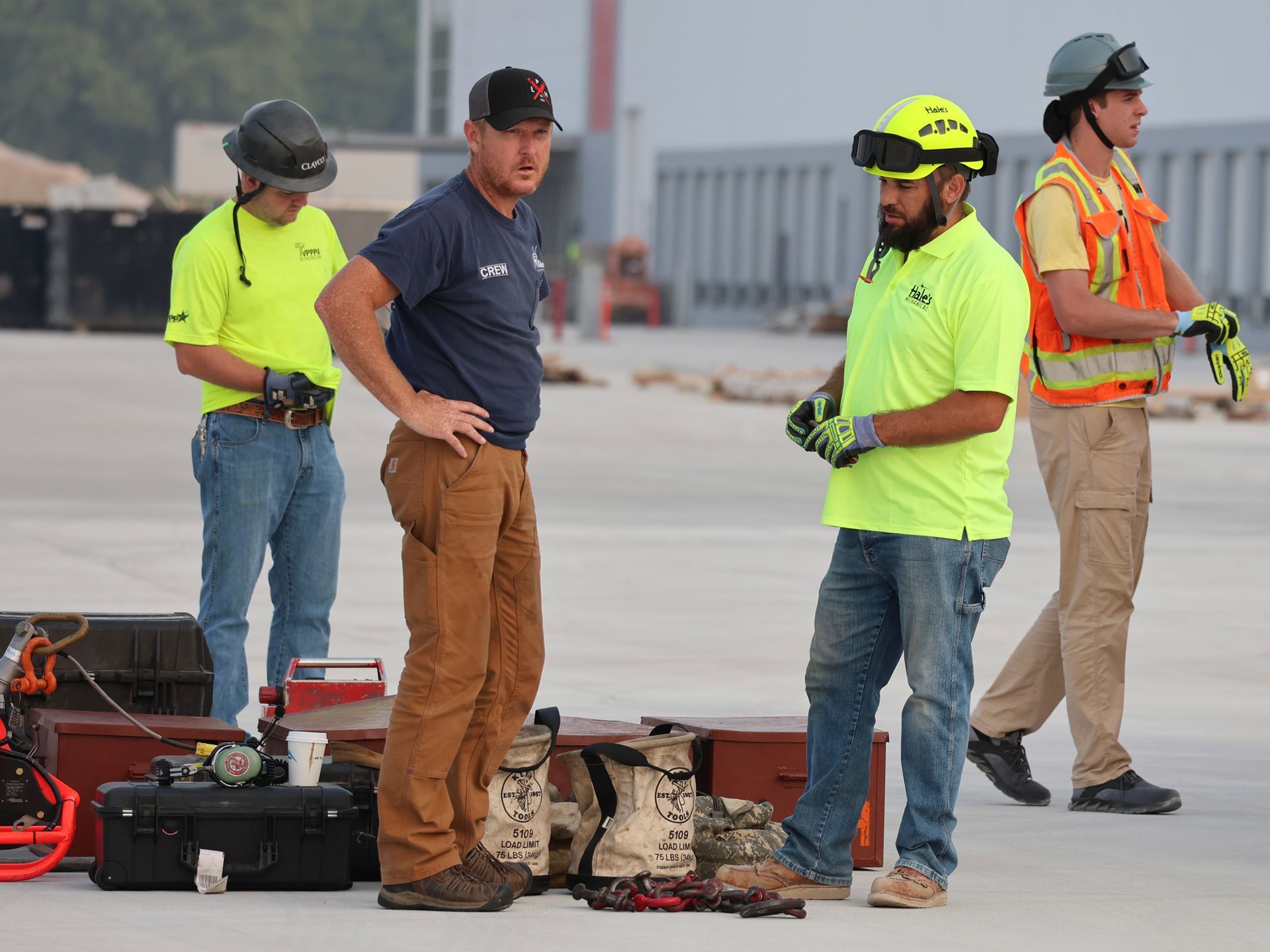A group of construction workers are standing on a concrete surface.