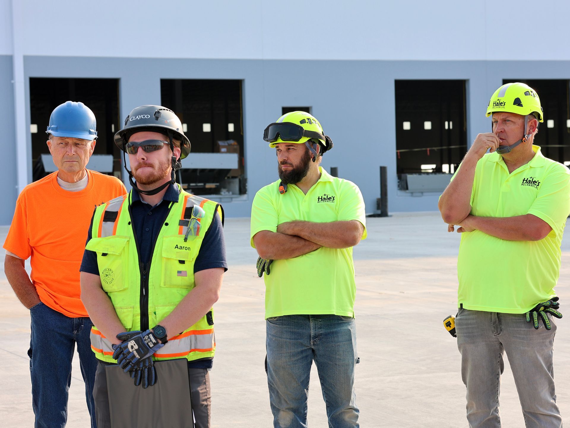 A group of construction workers wearing hard hats and safety vests