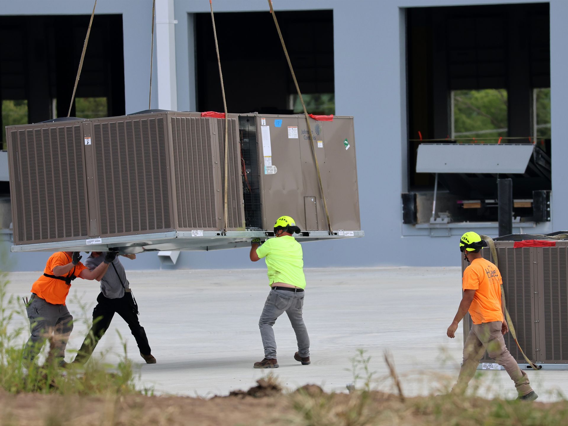 A group of construction workers are carrying a large box