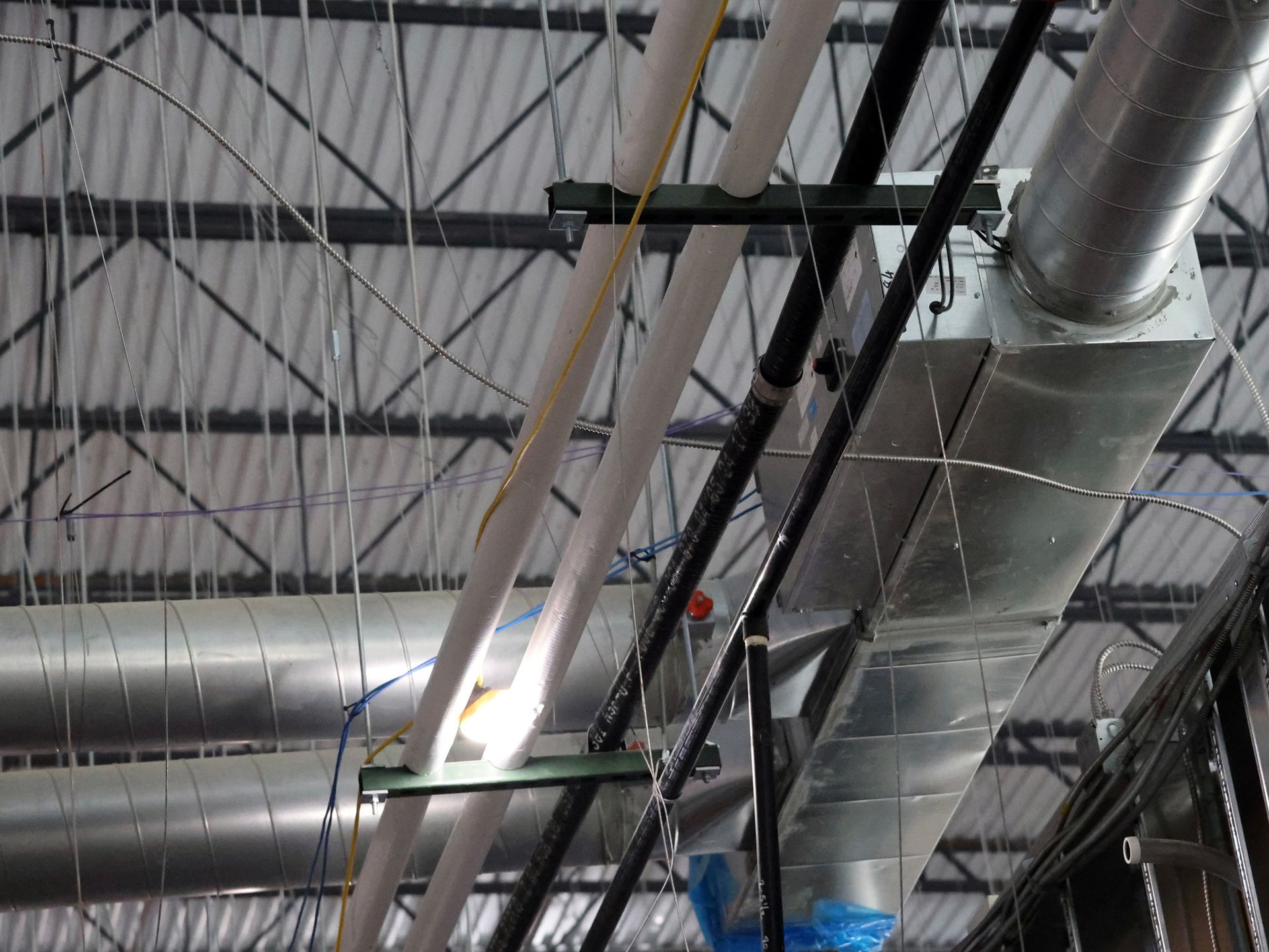 A ceiling with a lot of pipes hanging from it