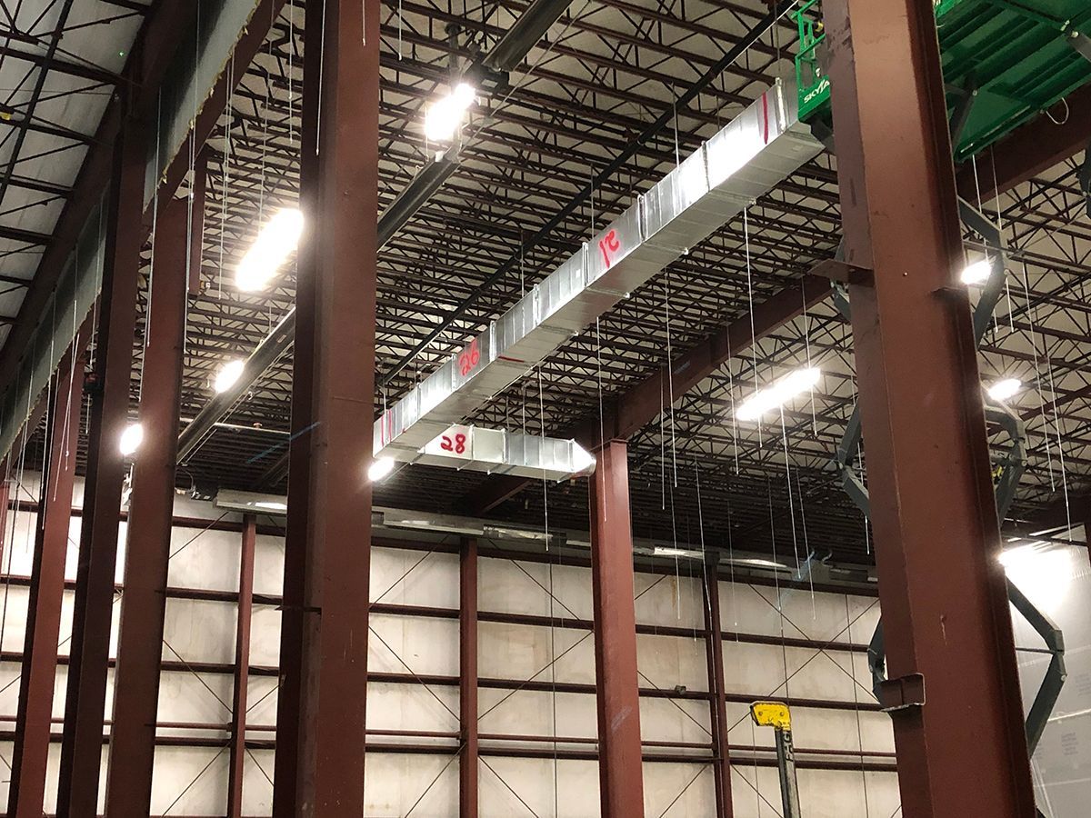 A large building with a lot of pipes hanging from the ceiling.