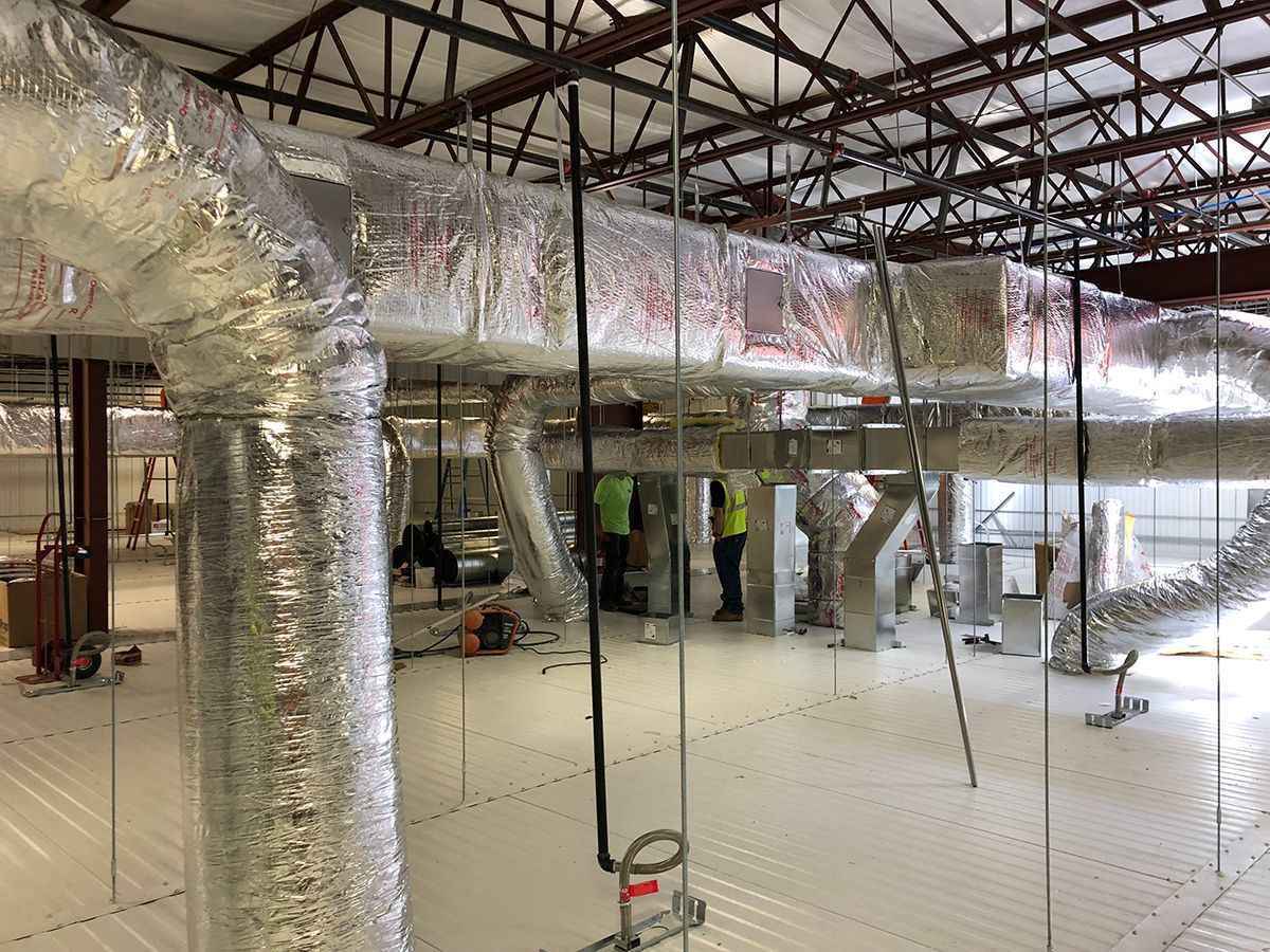 A large room with a lot of pipes hanging from the ceiling.