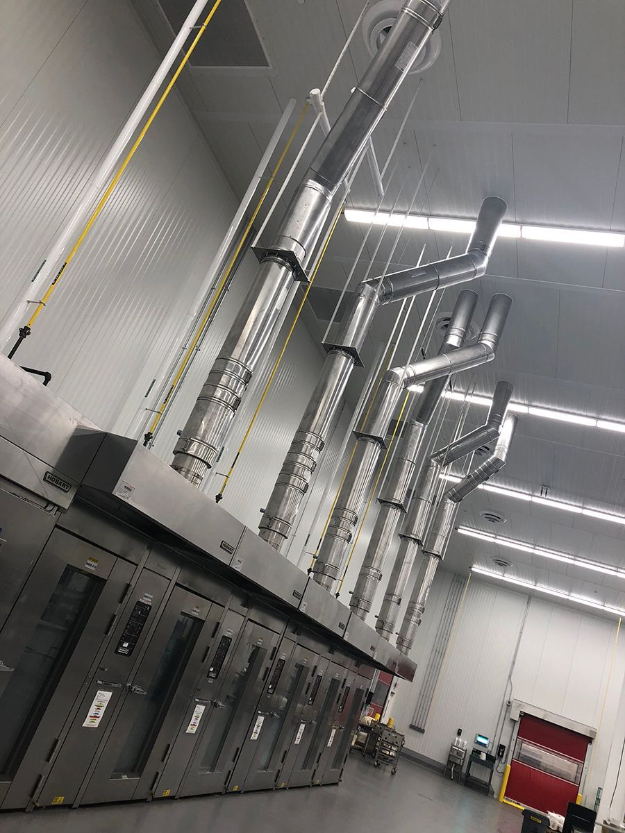 A large room with a lot of pipes hanging from the ceiling.