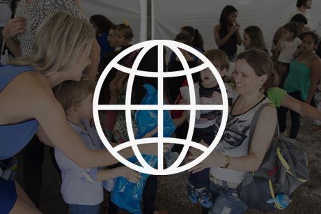 A group of people are hugging each other in front of a globe.