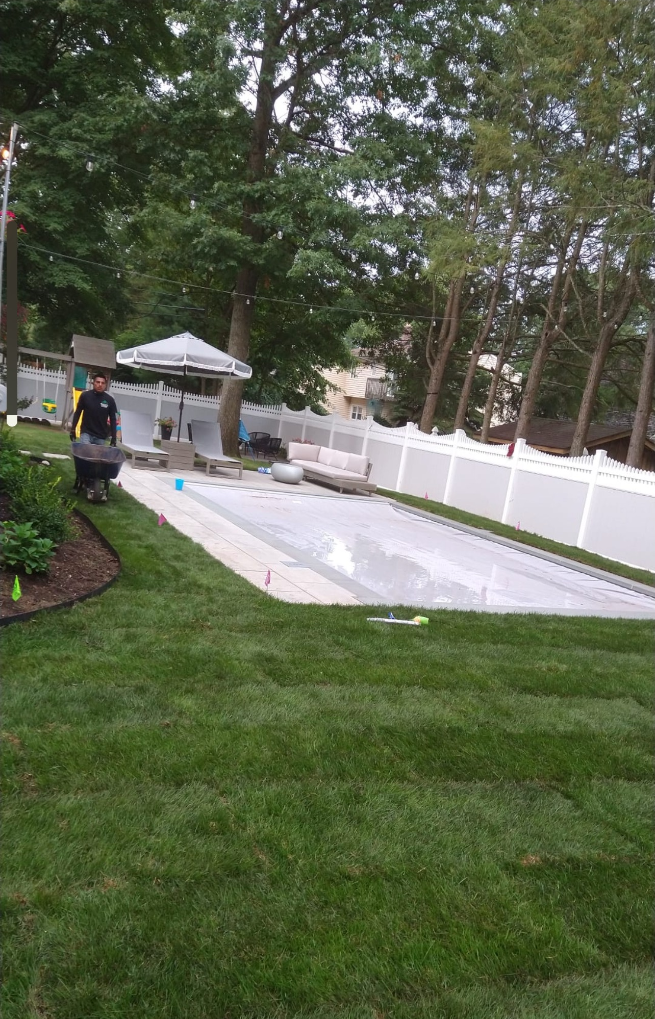 A man is working on a swimming pool in a backyard.