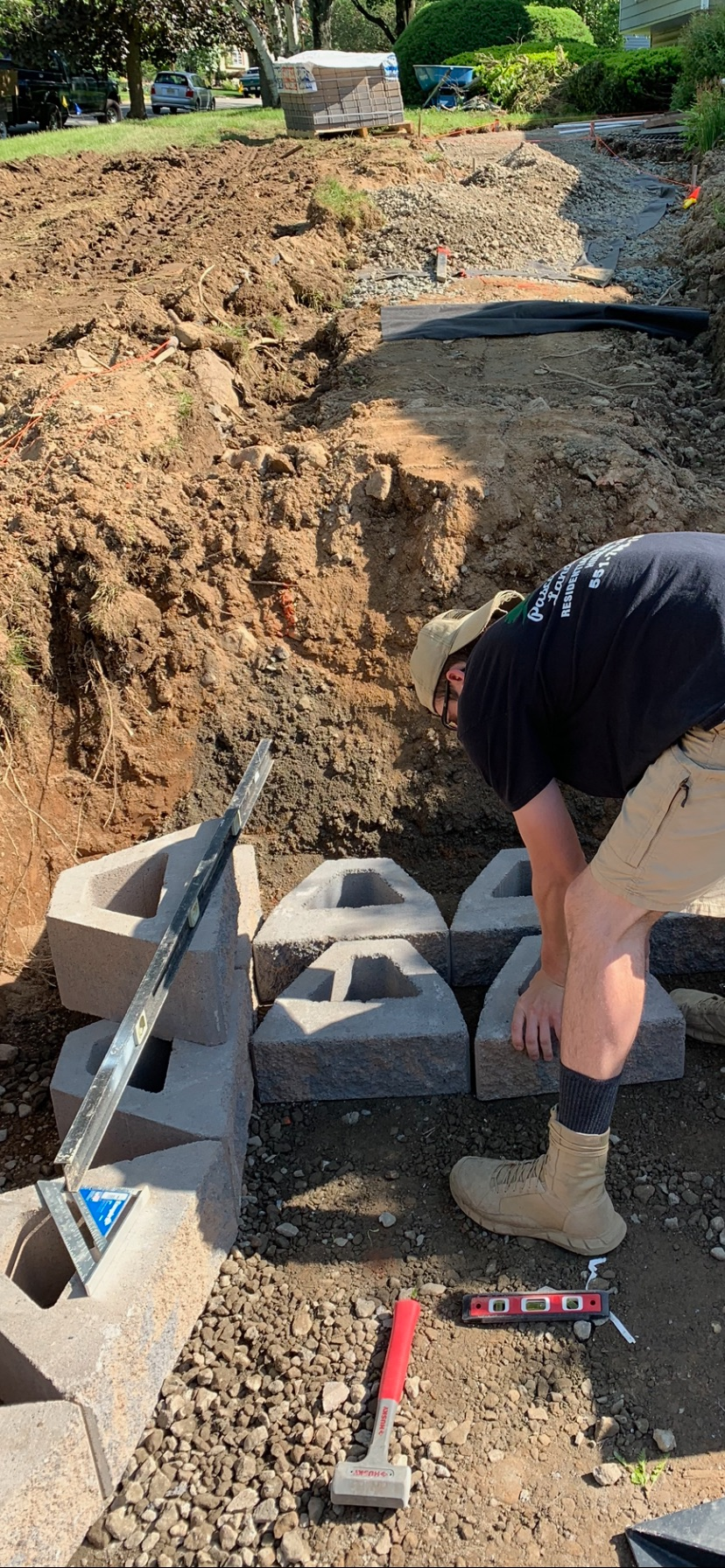 A man is working on a concrete structure in the dirt.