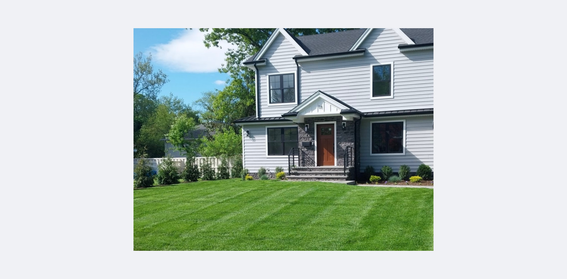 A large white house with a lush green lawn in front of it