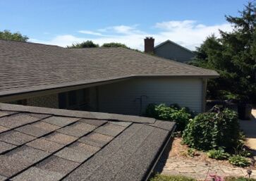 House roof with dark brown shingles featuring Gutter Cap.