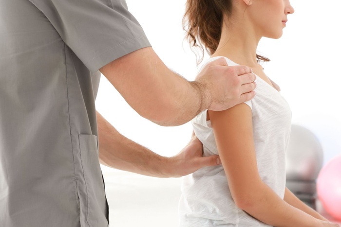 A man is giving a woman a massage on her back.