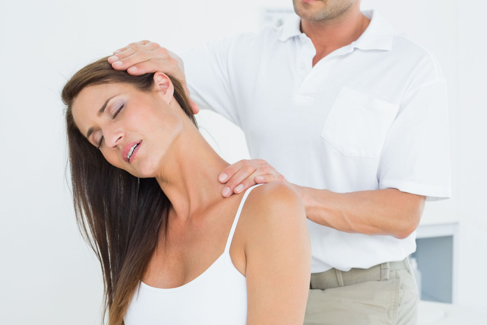 A man is giving a woman a neck massage.