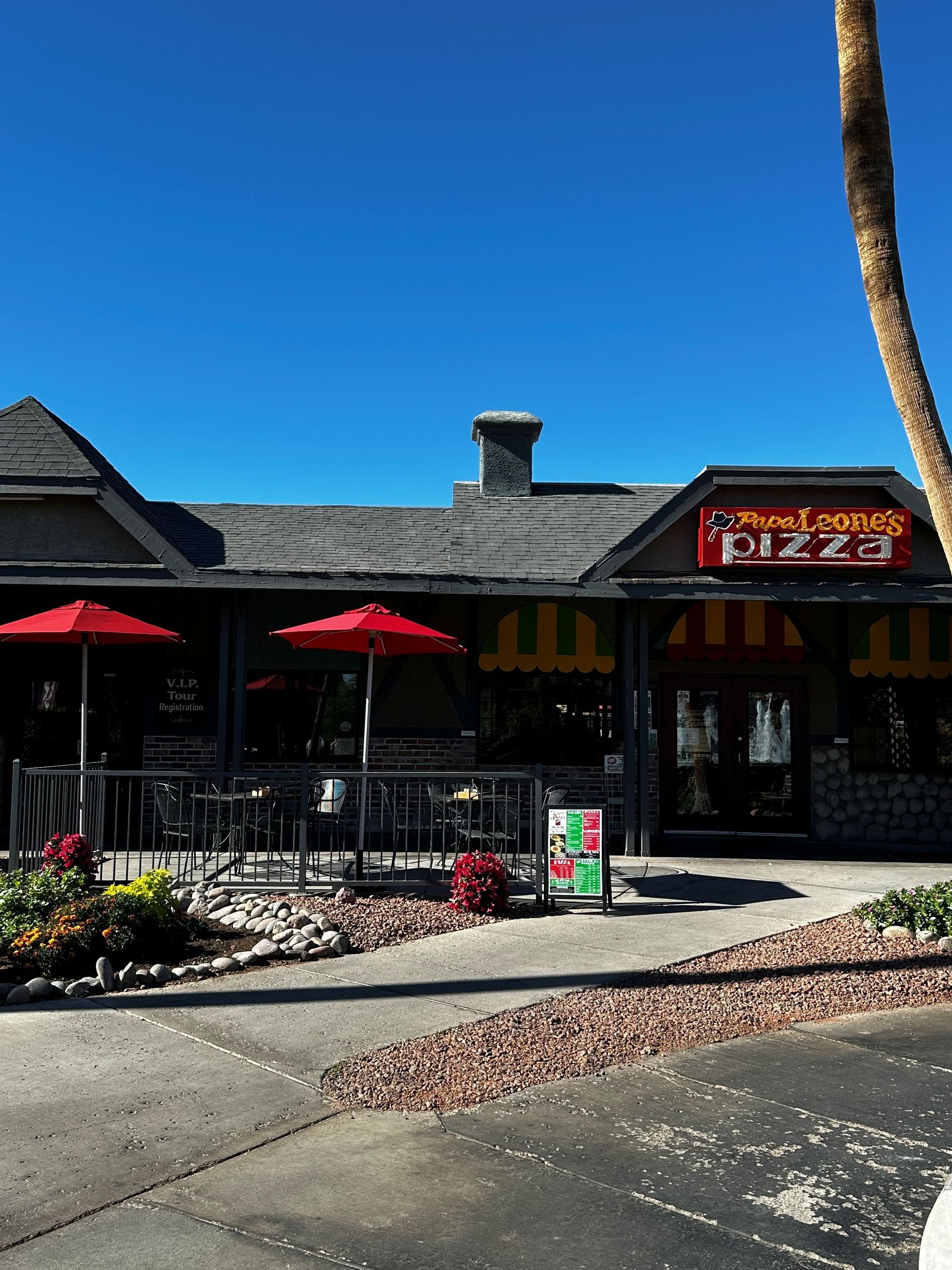 Restaurant exterior with red umbrellas, a sign that reads