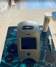 a WaterLink Spin Touch machine is on a table next to a syringe