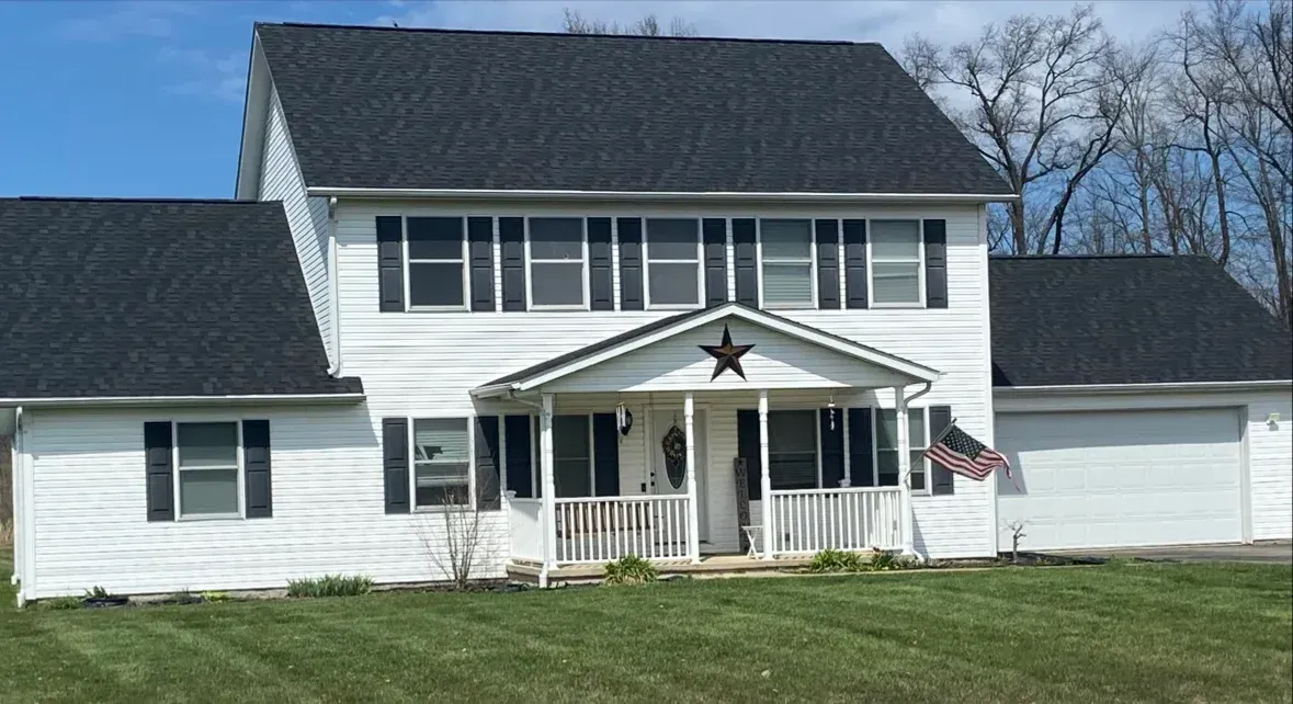 White farmhouse with porch and star decoration on a sunny day