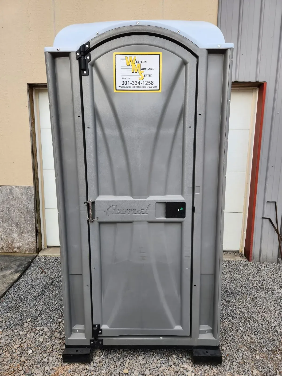 Gray portable toilet with an arched door, black hardware, and business logo.