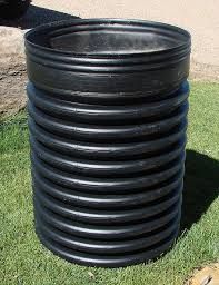 Black corrugated plastic cylinder on green grass.