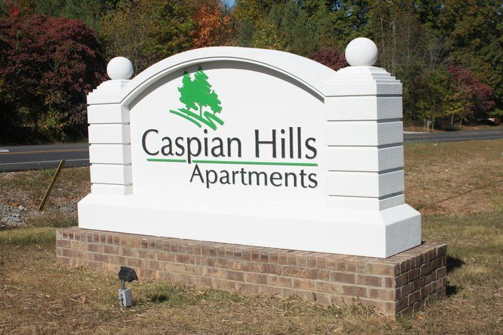 A large white sign for caspian hills apartments
