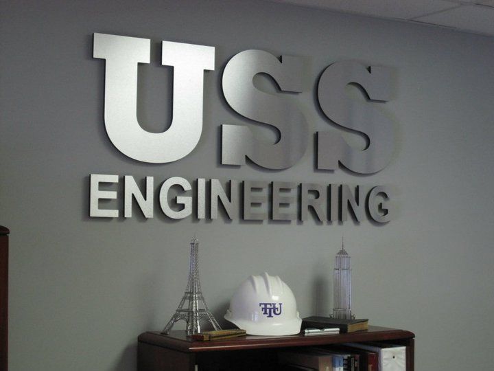 A sign for uss engineering hangs on a wall
